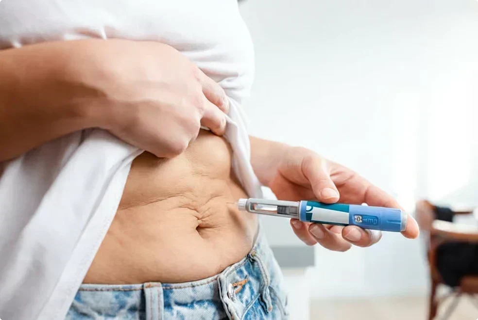 Person checking abdominal belly fat with a glucose monitoring device, illustrating visceral fat around the midsection